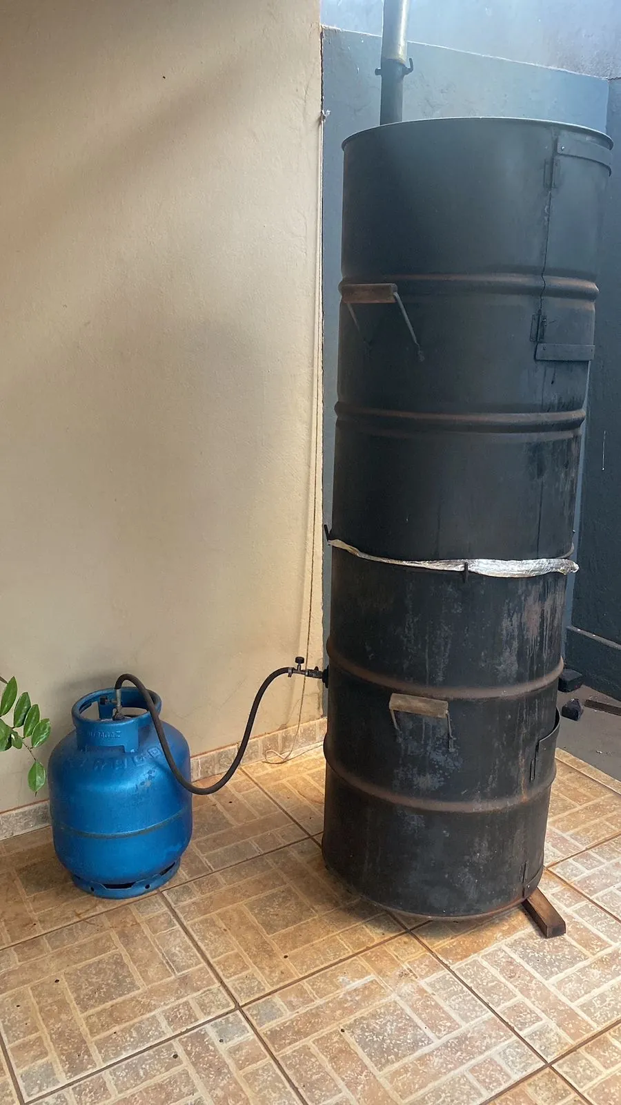 Defumador artesanal montado com dois tambores de 200 litros, ligado a um botijão de gás